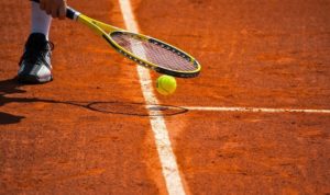 Terrain de tennis, raquette et balle jaune