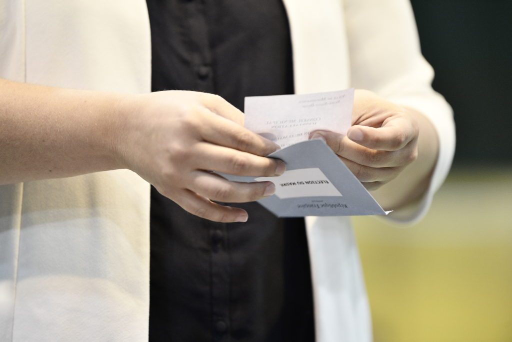 Mains de femme tenant un bulletin de vote
